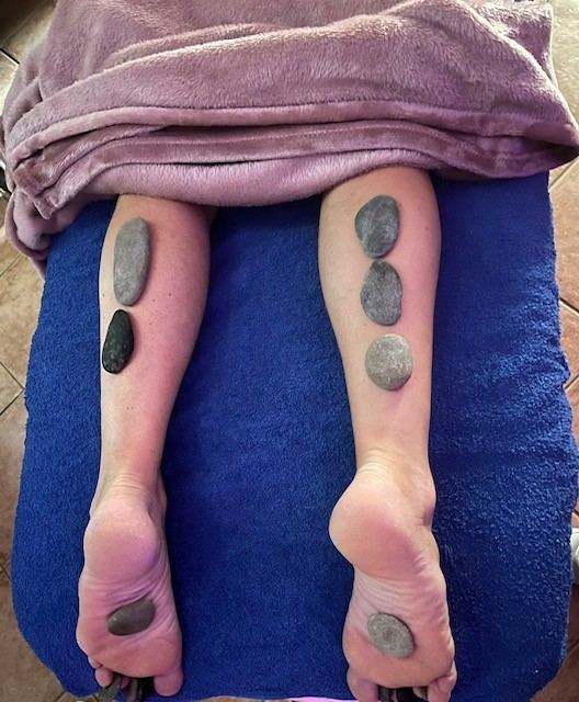 Pierres chaudes sur les mollets et les pieds
